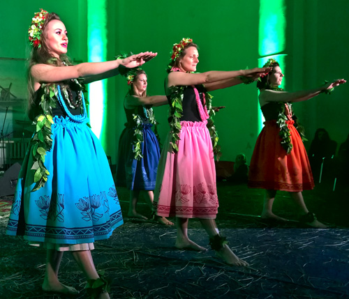 Women dancing hula dance in modern folk clothing